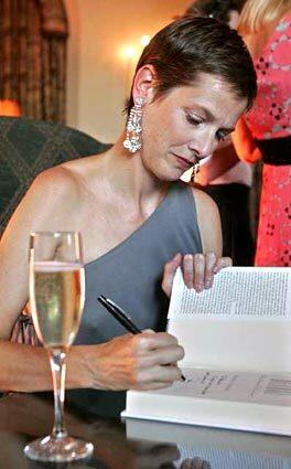 Author Dana Thomas signs a copy of her new book, "Deluxe: How Luxury Lost Its Luster," Aug. 30 at the Chateau Marmont.