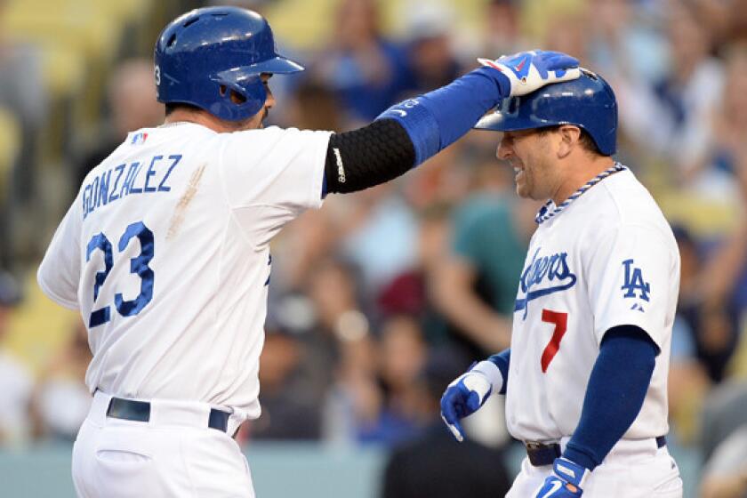 Dodgers utility player Nick Punto (7) get a pat on the head from first baseman Adrian Gonzalez, who hit a three-run home run against against the Miami Marlins earlier this month.