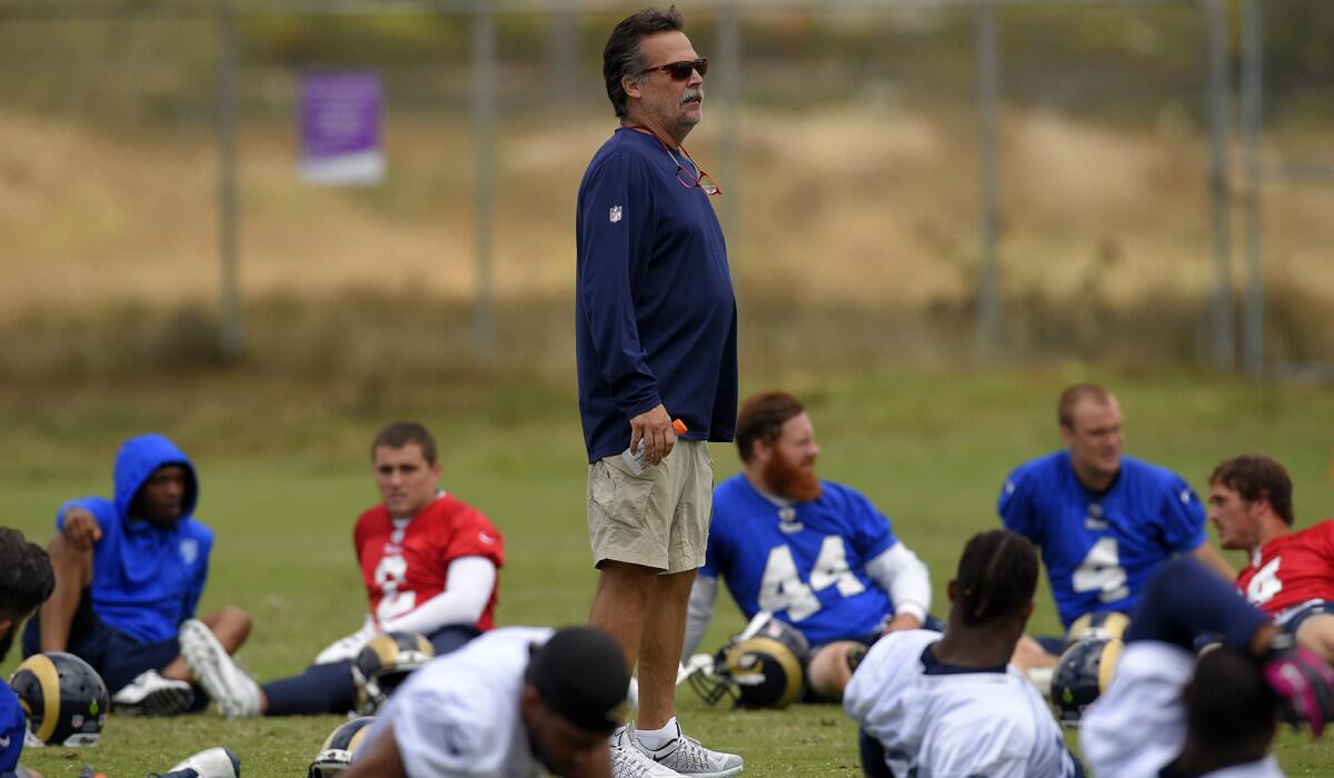 Los Angeles Rams Coach Jeff Fisher stands among his players during practice in Oxnard on June 14.