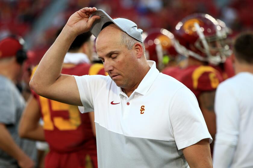 USC coach Clay Helton removes his cap after the Trojans defeated UCLA on Nov. 23 at the Coliseum.