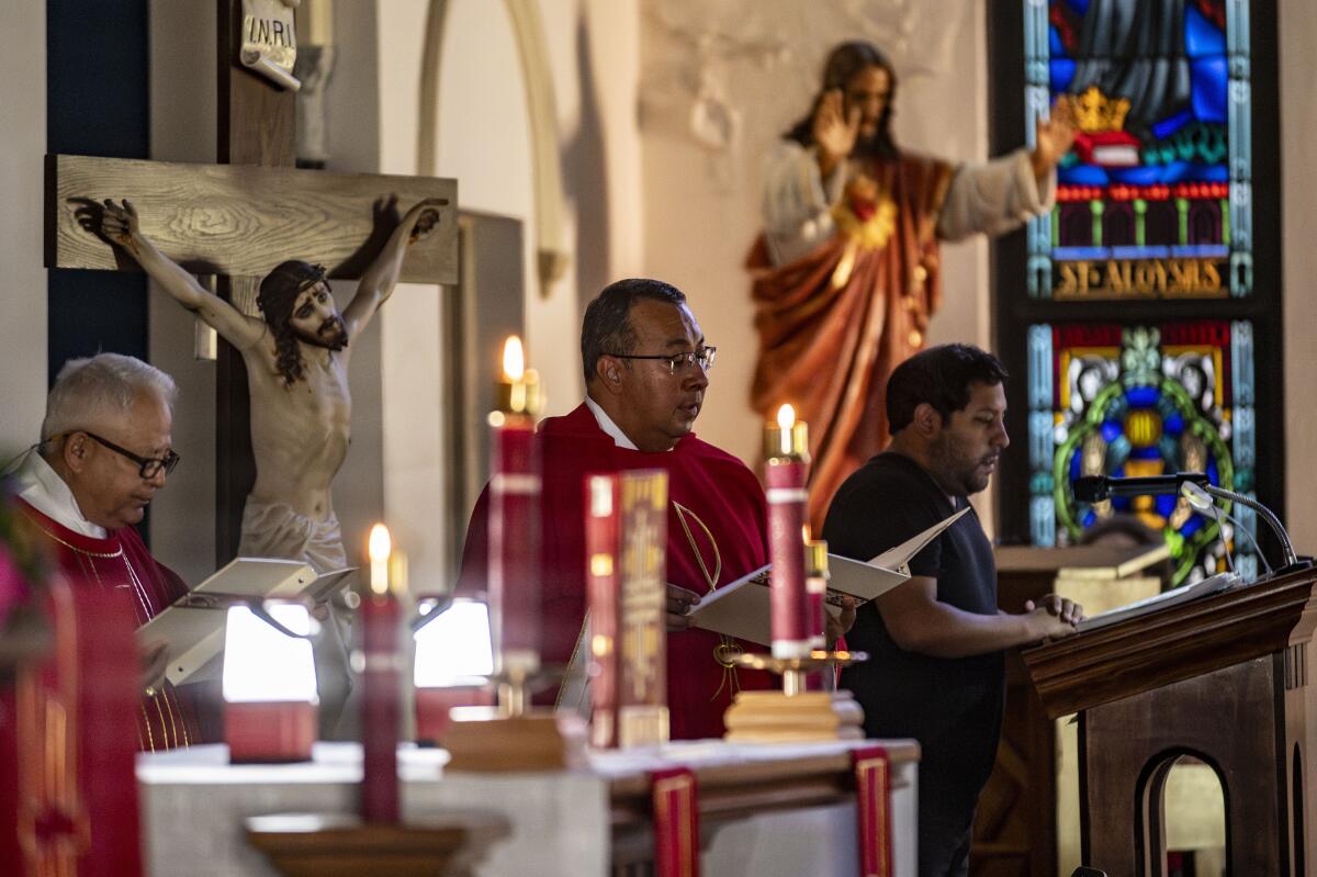 Father Elias Lopez reads by candle light during morning mass.