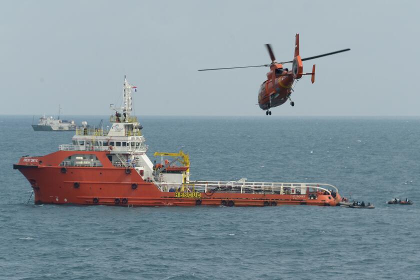 An Indonesian rescue helicopter approaches the Crest Onyx ship as divers conduct search operations for AirAsia Flight 8501 on the Java Sea on Jan. 9.