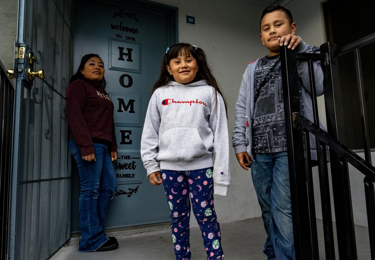 Three people outside a door.