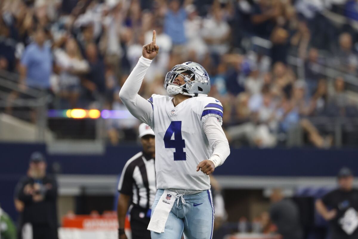 Dallas Cowboys quarterback Dak Prescott (4) celebrates after throwing a touchdown pass to tight end Blake Jarwin in the first half of a NFL football game against the Carolina Panthers in Arlington, Texas, Sunday, Oct. 3, 2021. (AP Photo/Ron Jenkins)