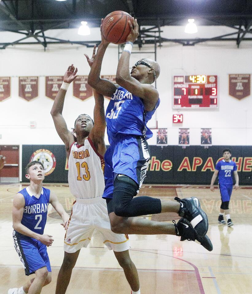 Burbank's Jalen Clark grabs a rebound and puts back the shot against Arcadia's Jalen Harris in the first half of a Pacific League boys' basketball game at Arcadia High School on Tuesday, January 15, 2019.