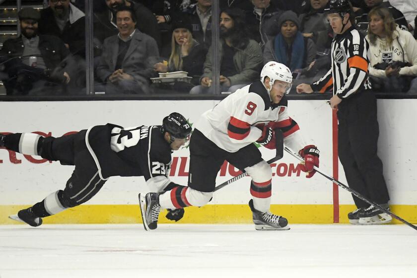 Los Angeles Kings right wing Dustin Brown, left, dives for the puck as New Jersey Devils left wing Taylor Hall takes it from him during the first period of an NHL hockey game Thursday, Dec. 6, 2018, in Los Angeles. (AP Photo/Mark J. Terrill)