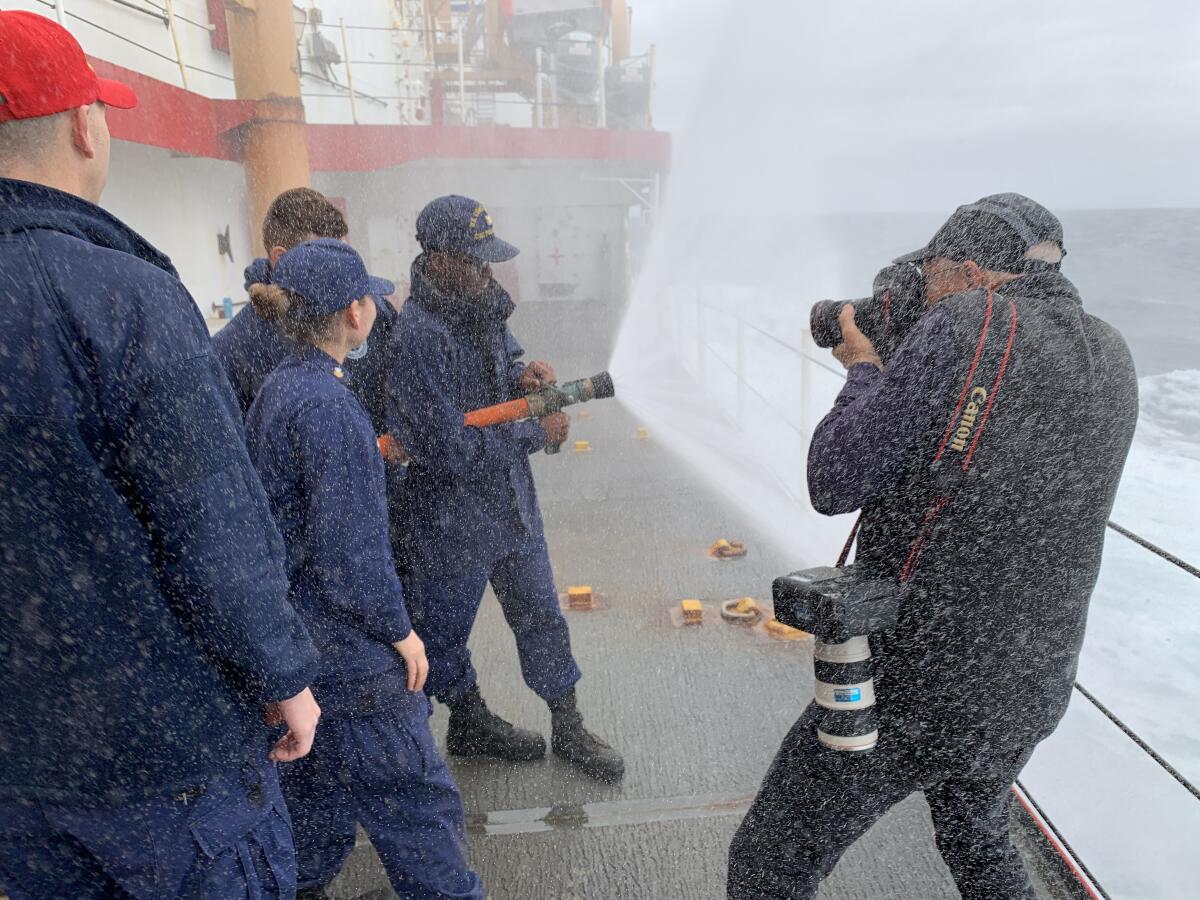 L.A. Times photographer Brian van der Brug gets soaked while shooting Coast Guard crew members training to fight fires aboard the Polar Star.