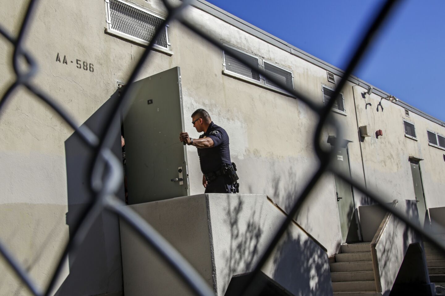 L.A. Unifed Police Officer Jose Zamora looks inside a classroom while conducting a safety check at Theodore Roosevelt High School in Los Angeles.