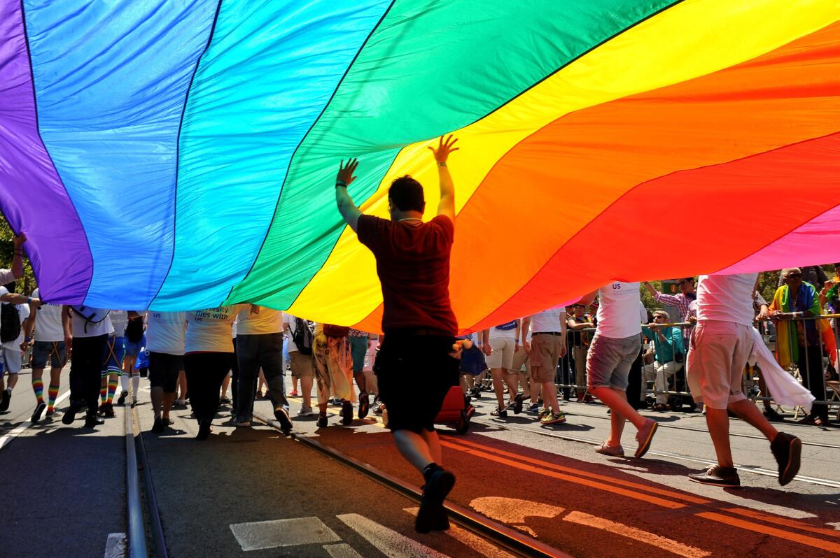 A rainbow flag, a universal symbol for gay civil rights, is carried down San Francisco's Market Street in the city's annual Gay Pride parade on June 30, 2013.