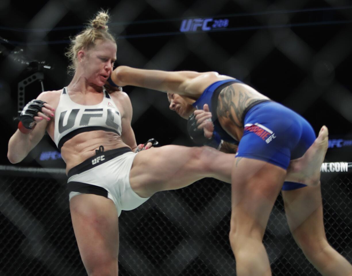 Holly Holm kicks Germaine de Randamie, of the Netherlands, during a women's featherweight championship mixed martial arts bout at UFC 208 early Sunday, Feb. 12, 2017, in New York. De Randamie won the fight. (AP Photo/Frank Franklin II)
