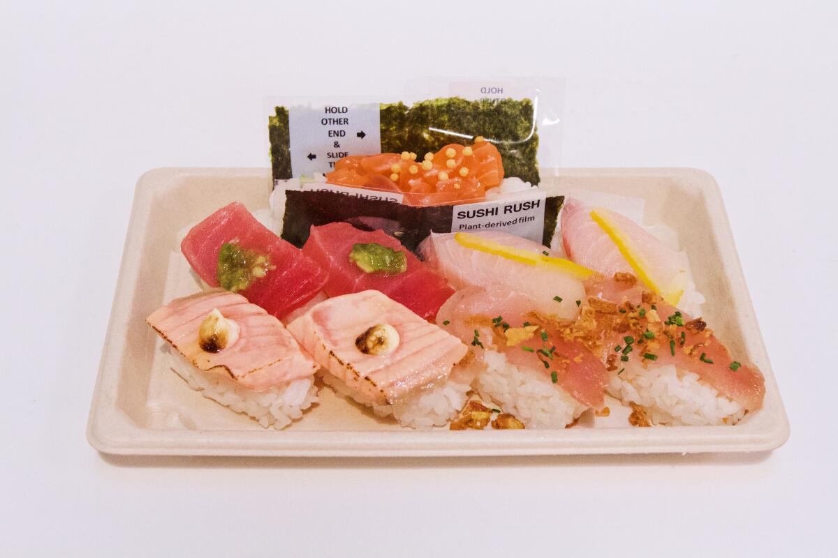 A nigiri sampler on a cardboard tray with one salmon temaki from Grand Central Market vendor Sushi Rush