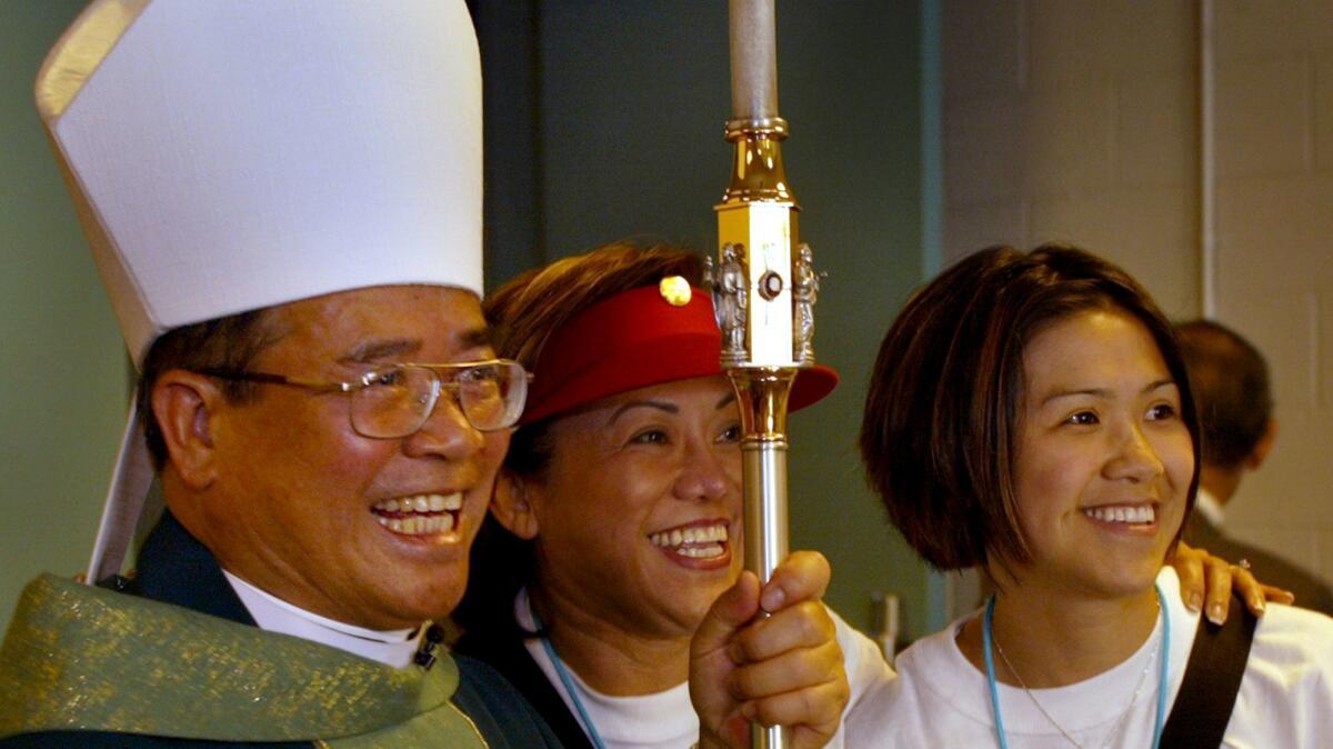 The first VietnameseAmerican bishop, Dominic Luong poses with parishioners after a 2003 Mass at UC Irvine