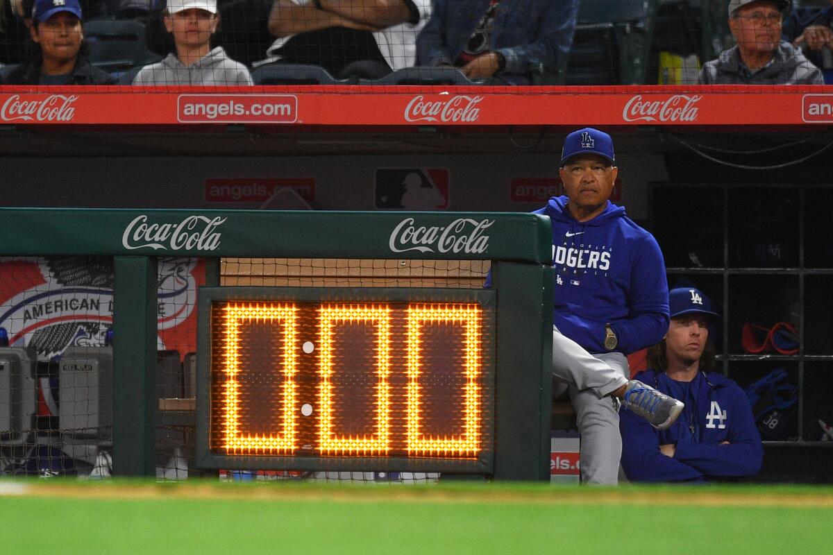 Dodgers manager Dave Roberts looks on from the dugout as the pitch clock expires 