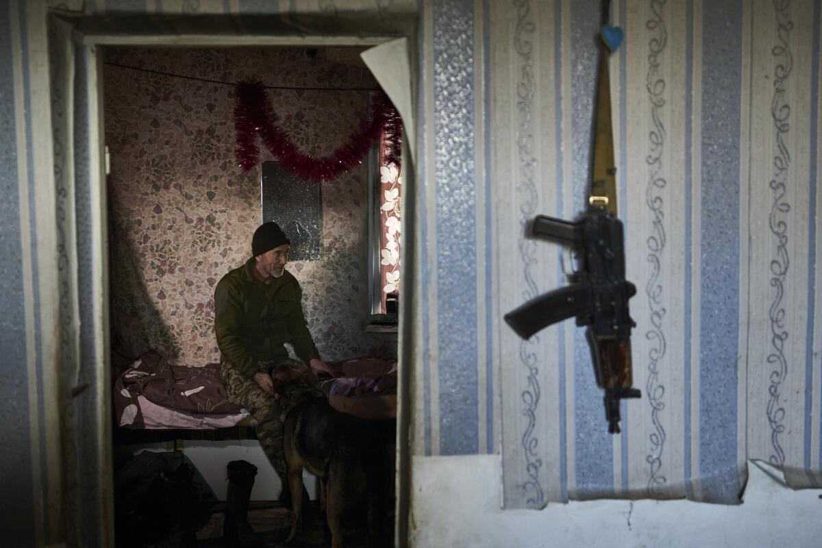 Ukrainian soldier petting a dog inside a house