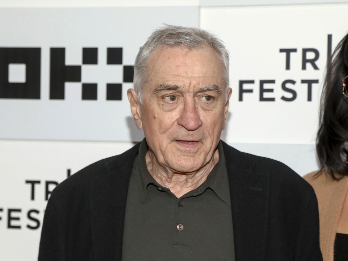 Actor Robert De Niro in a dark shirt and cardigan looking slightly to his left