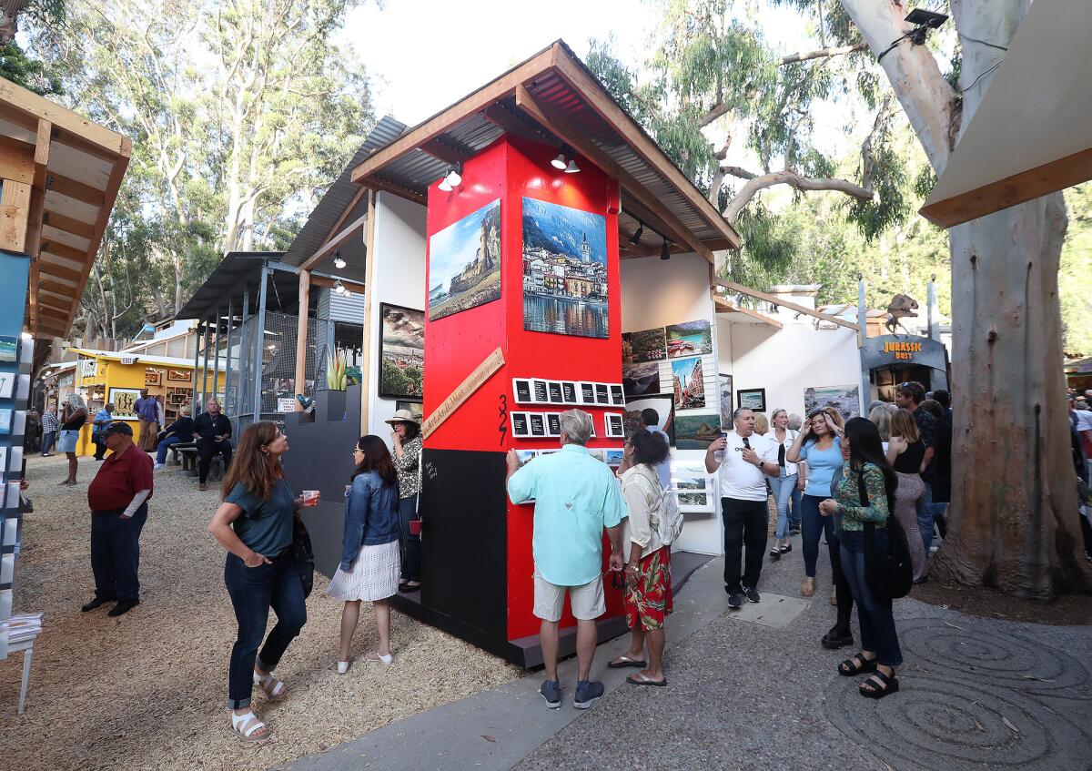 Guests surround the booth of artist Krishnan Iyer during the 2022 Sawdust Festival preview night in Laguna Beach.
