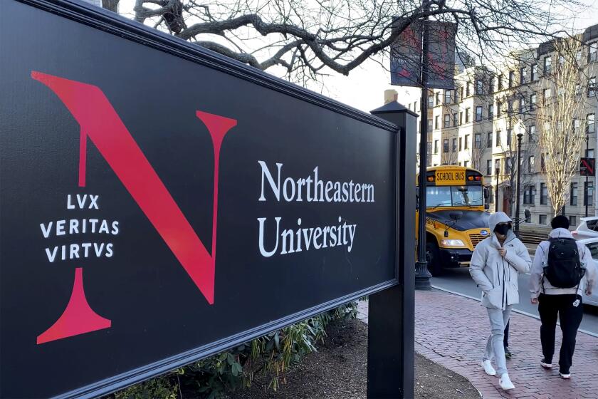 FILE - Students walk on the Northeastern University campus in Boston on Jan. 31, 2019. A police bomb squad sealed off part of the campus of Northeastern University late Tuesday, Sept. 13, 2022, to examine a pair of suspicious packages, and there were unconfirmed reports of an explosion and minor injuries to at least one person. (AP Photo/Rodrique Ngowi, File)