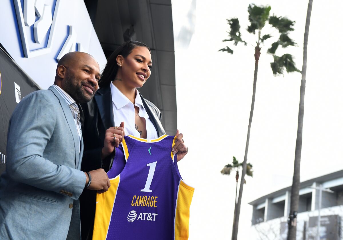New Sparks player Liz Cambage and general manager and coach Derek Fischer hold a jersey.