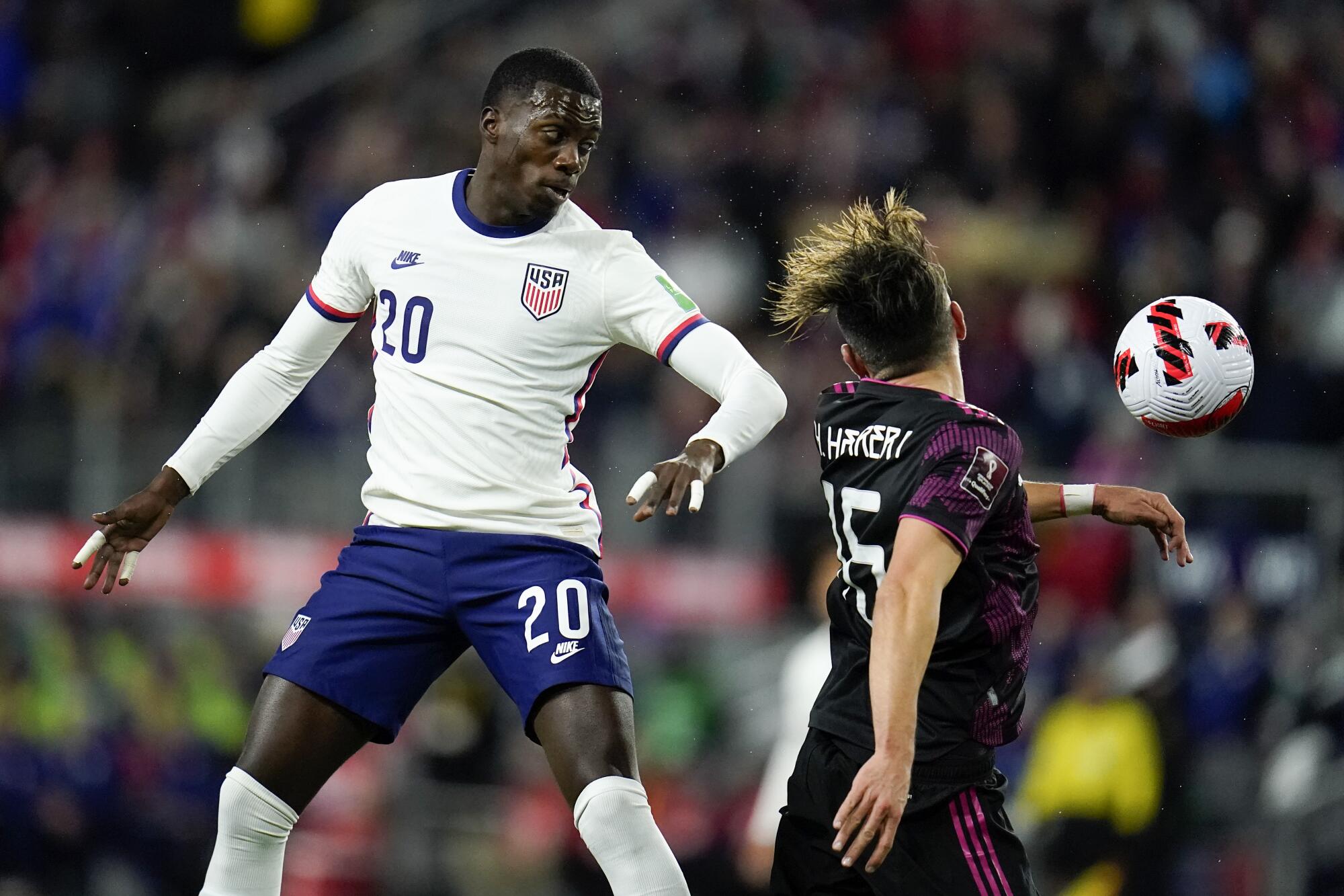 United States' Tim Weah, left, goes up for the ball against Mexico's Hector Herrera 