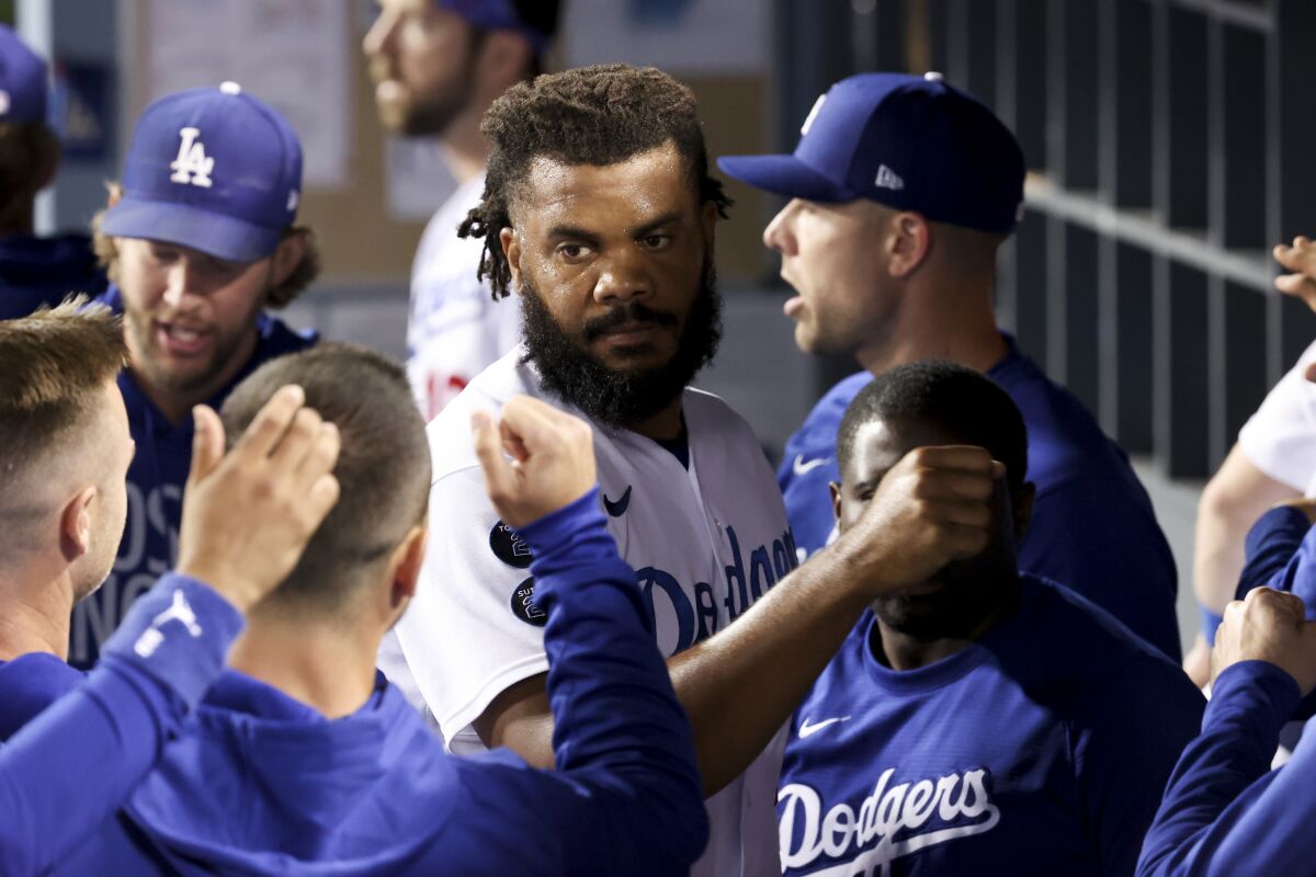 Dodgers relief pitcher Kenley Jansen celebrates with teammates in the dugout.