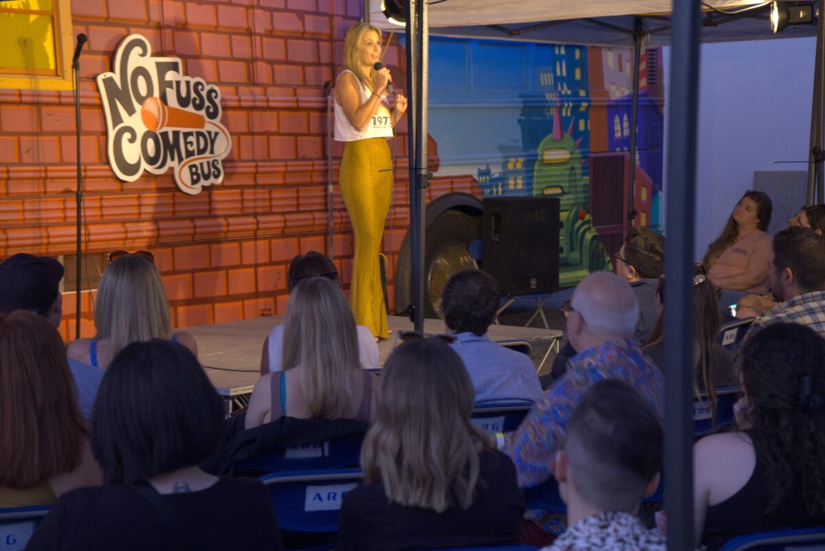 A woman on an outdoor comedy stage