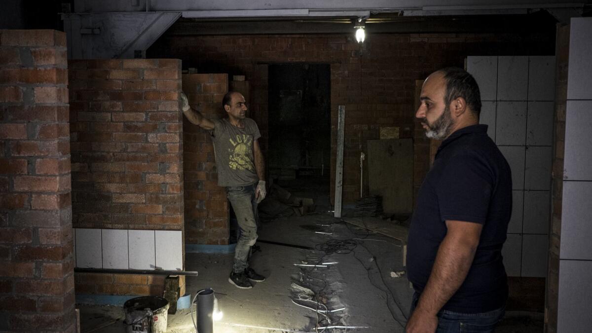 Workers at a site where the Dog Patrol center for homeless dogs is being built. A former garage is being renovated by the volunteers to become the center for stray dogs