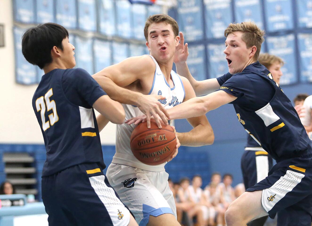 Corona del Mar's John Humphreys is fouled as he turns to shoot in the paint during the CdM Beach Bash tournament opener against Crean Lutheran on Monday.