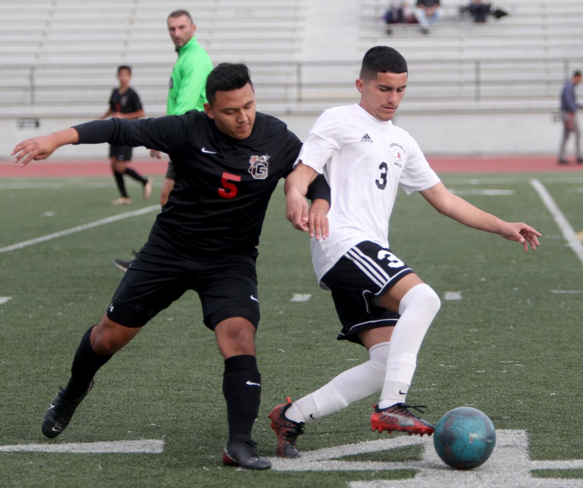 Glendale High's Elijah Cruz, left, tries to get the ball from Burroughs' Manny Gonzalez during Tuesday's Pacific League match at Glendale.