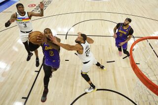 LeBron James, alero de los Lakers de Los Ángeles, salta para encestar ante Rudy Gobert, de los Timberwolves de Minnesota, el viernes 31 de marzo de 2023 (AP Foto/Abbie Parr)