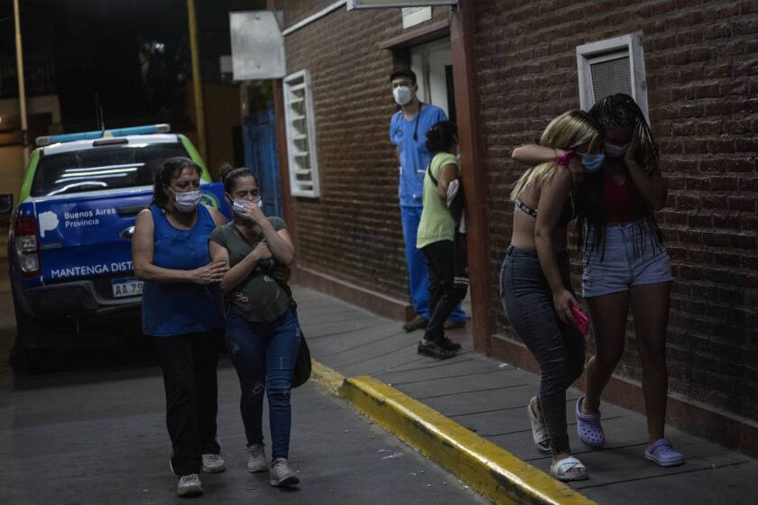 Relatives and friends of people who were poisoned with adulterated cocaine cry after talking to doctors outside the emergency room of a hospital in the outskirts of Buenos Aires, Argentina, Wednesday, Feb. 2, 2022. According to local authorities, more than a dozen people have died and at least 50 seriously sickened after consuming adulterated cocaine. (AP Photo/Rodrigo Abd)