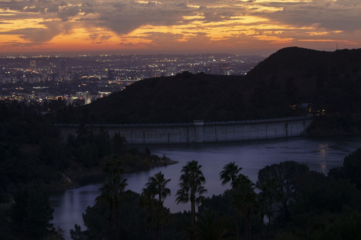 Passing rain clouds provide another colorful sunset as seen over the Hollywood Reservoir on Thursday.