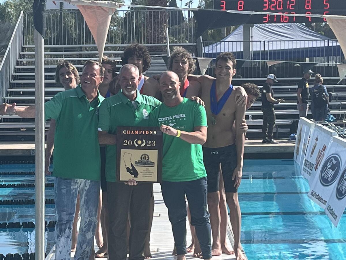 Costa Mesa High swim coaches Chuck Olson, Diggy Riley and Keith Ryan, from left, show off the Division 3 plaque.