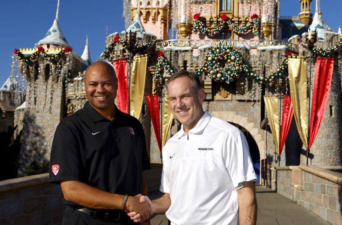 Coaches David Shaw, left, of Stanford and Mark Dantonio of Michigan State pose for photos at Disneyland before a news conference Thursday.