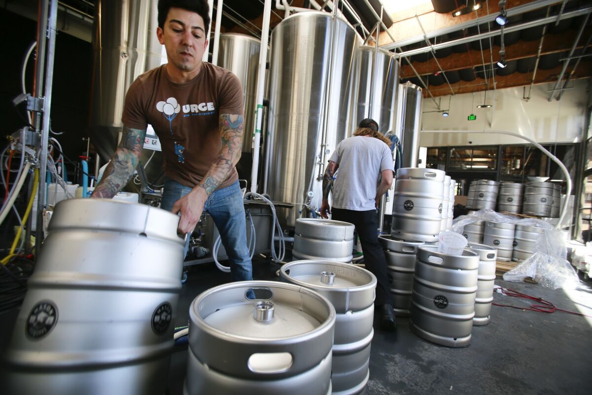 Jason De La Torre head brewer at Oceanside Mason Ale Works in Oceanside, prepares kegs for cleaning.