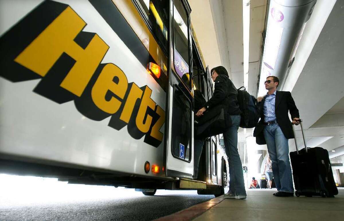 Passengers board a Hertz courtesy bus outside Los Angeles International Airport.
