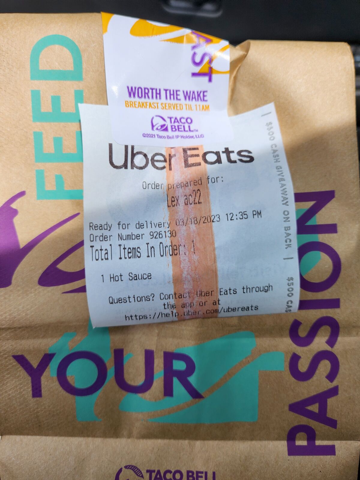An Uber Eats note is attached to a Taco Bell bag.