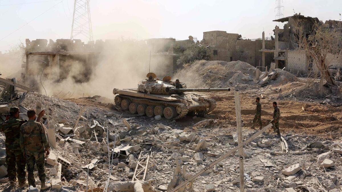 Syrian government forces advance through Qaboun, on the outskirts of Damascus, during an offensive to retake the area from opposition fighters on May 13.