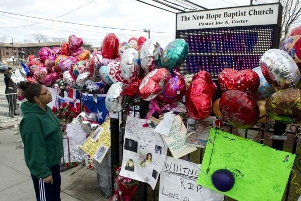 A woman reads messages at a memorial for Houston set up outside the New Hope Baptist Church in Newark, N.J.