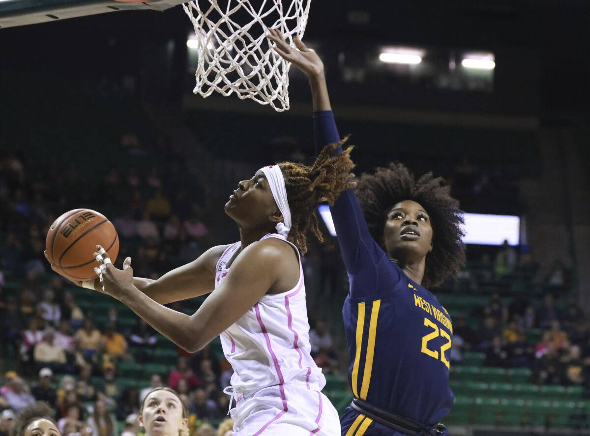 Baylor forward NaLyssa Smith, left, drives past West Virginia center Blessing Ejiofor, right, in the first half of an NCAA college basketball game, Saturday, Feb. 12, 2022, in Waco, Texas. (Rod Aydelotte/Waco Tribune-Herald via AP)