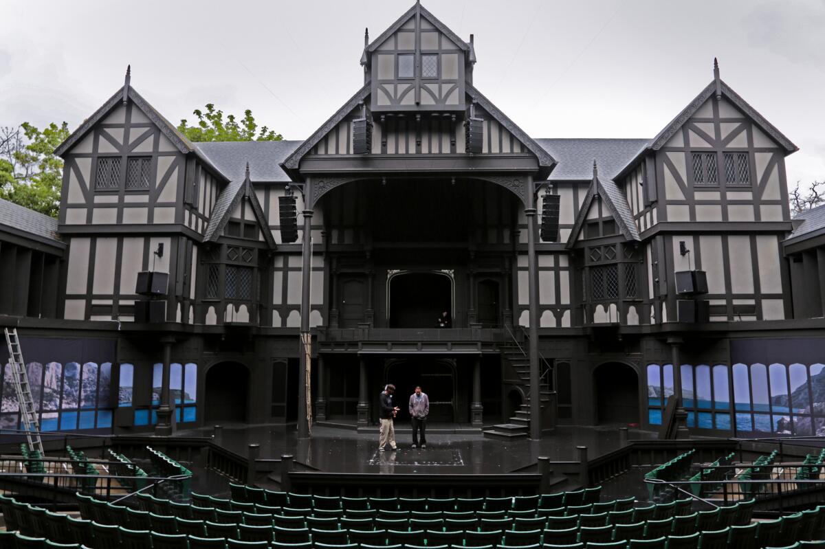 A half-timbered building at the rear of an outdoor stage with semicircular seating area