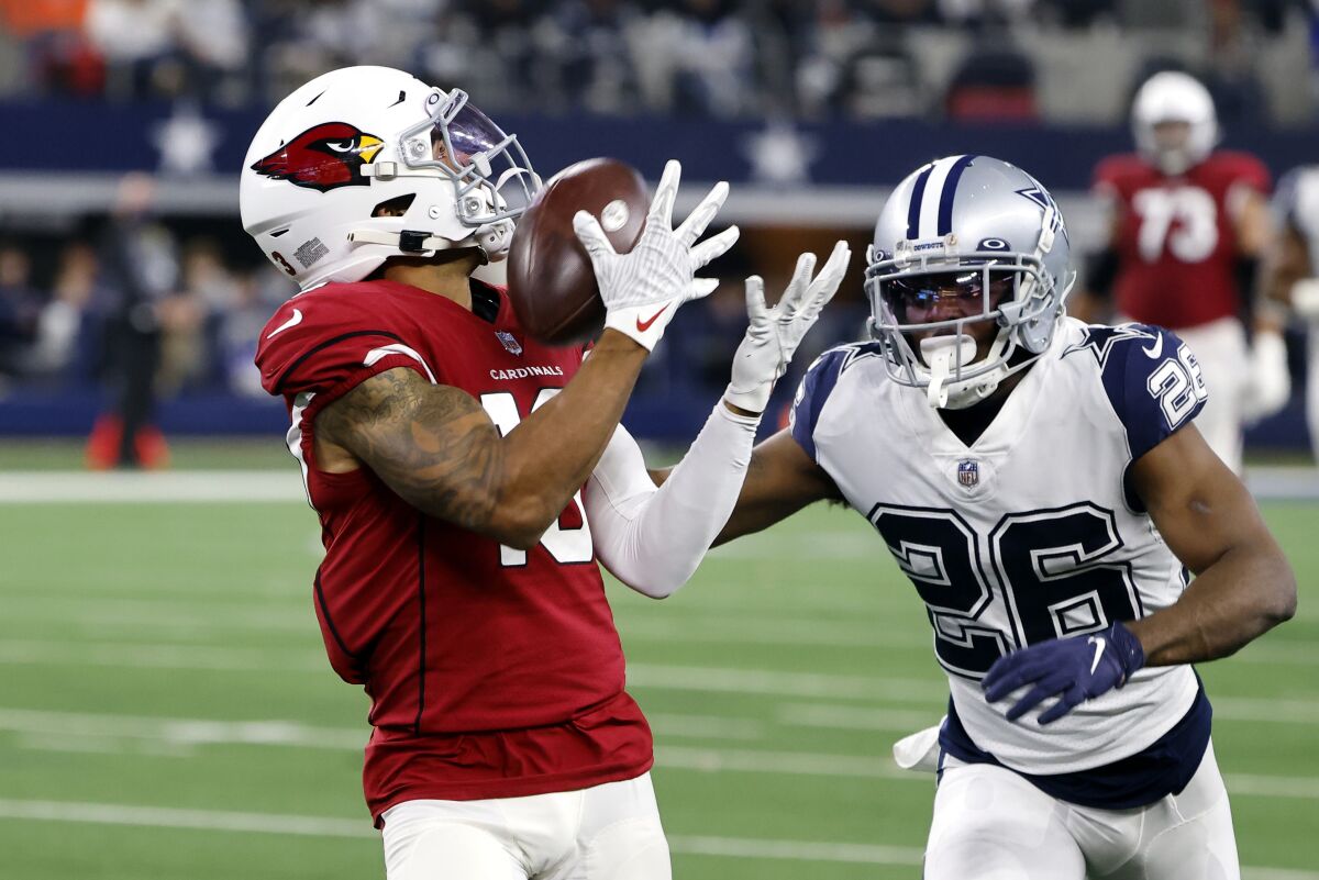 Arizona Cardinals wide receiver Christian Kirk (13) catches a pass for a first down as Dallas Cowboys cornerback Jourdan Lewis (26) defends during the second half of an NFL football game Sunday, Jan. 2, 2022, in Arlington, Texas. (AP Photo/Michael Ainsworth)