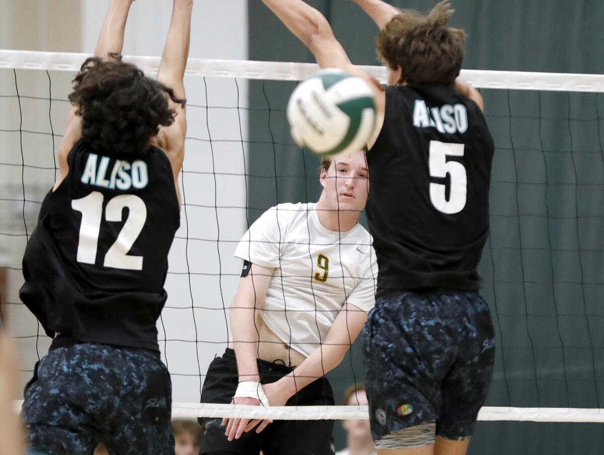 Edison's Owen Shaff (9) kills a ball past the block of Aliso Niguel's Anthony Diosdado (12) and Ty Carson (5).