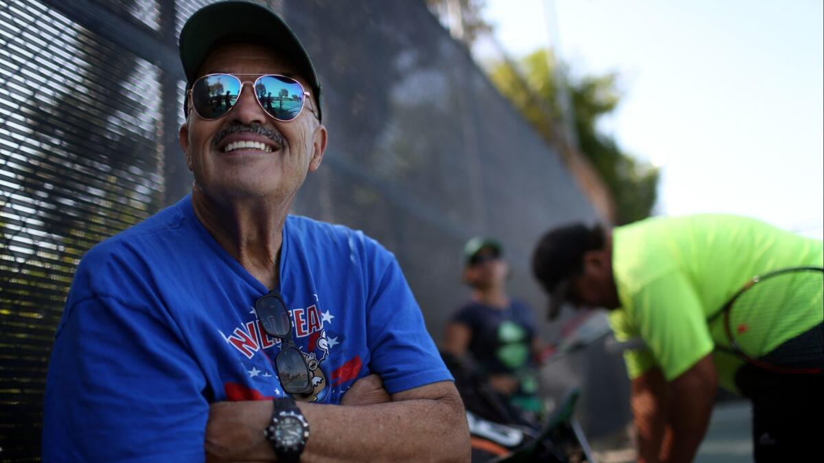 Juan Gonzalez rests after a tennis match in Downey. He meets several other mostly retired people here to play tennis about twice a week.