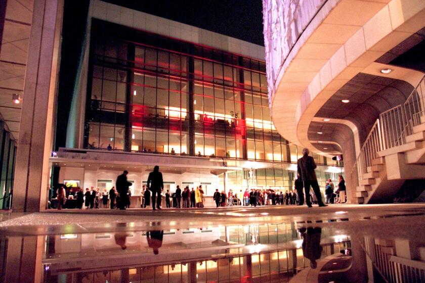 Theatre-goers braved the rain to attend the re-opening of the Ahmanson Theatre for the premiere of "Miss Saigon" in 1995. The national touring company of "Miss Saigon" opened a nine-month run at the Ahmanson Theatre. It was the first show to play the Ahmanson after the hall's $17-million reconfiguration was completed.