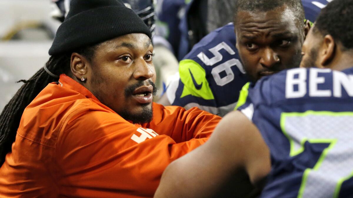 Retired running back Marshawn Lynch, left, chats on the sideline with former teammates during a game against the Panthers last December.