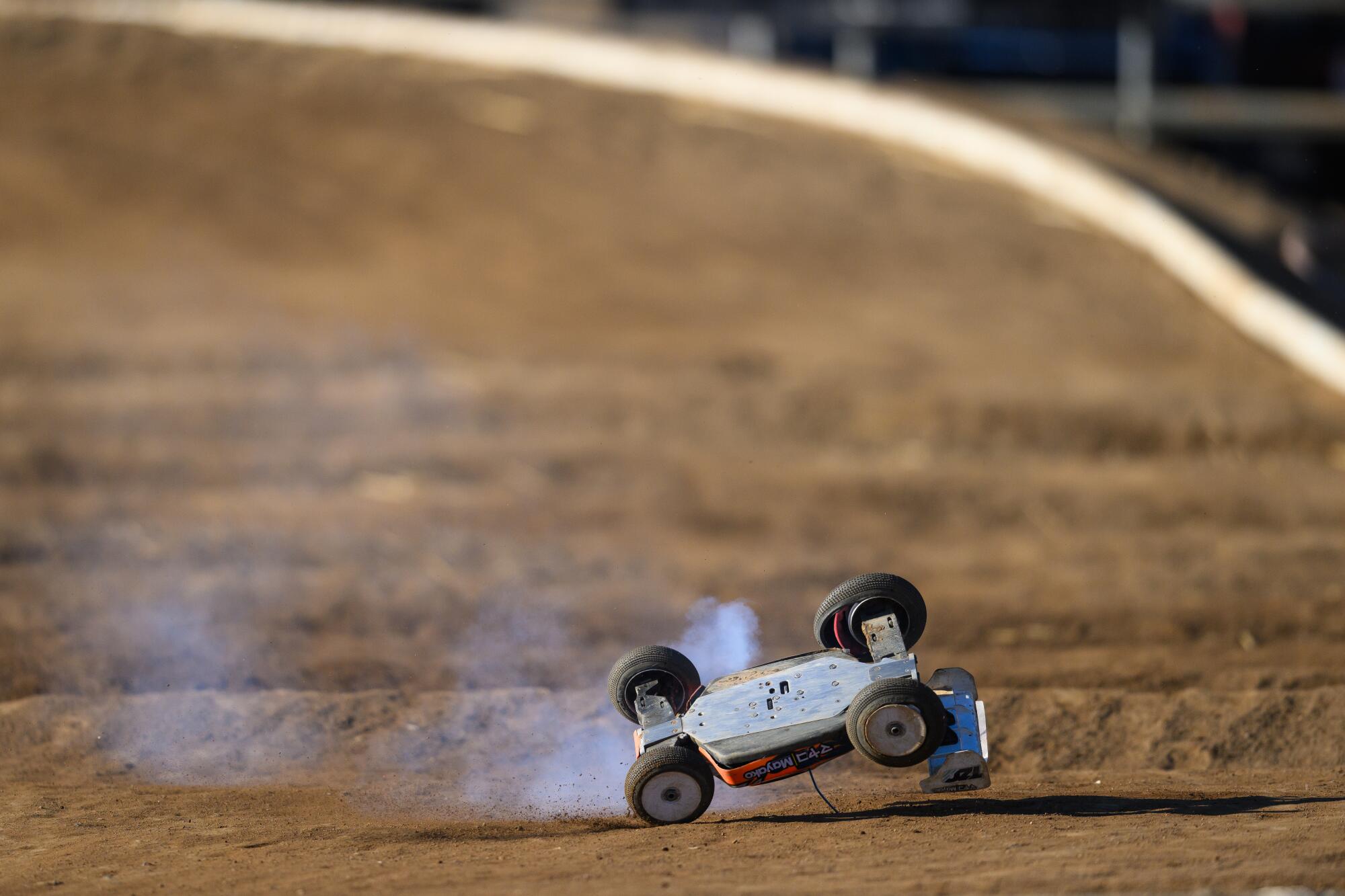 An RC car flips over after failing a turn on the track during the annual Dirt Nitro Challenge.