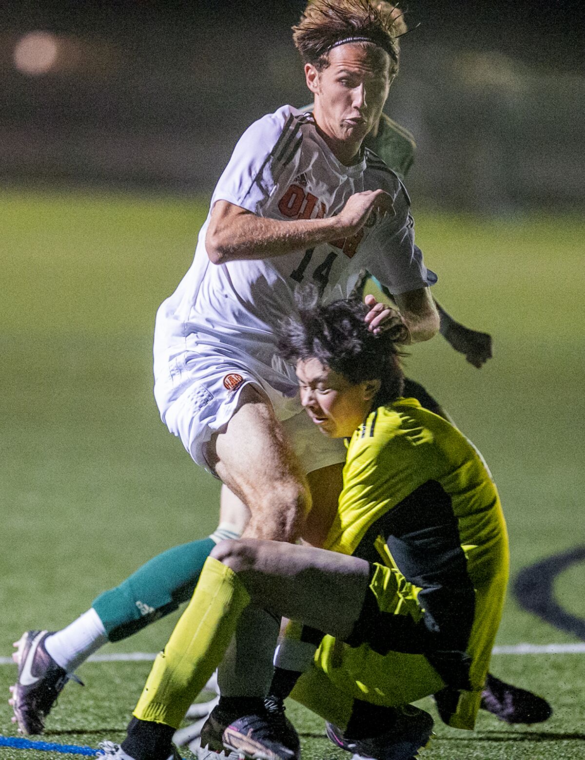 Huntington Beach's Hayden Kenny collides with Edison goalkeeper Dylan Dwight during a Surf League match on Wednesday.
