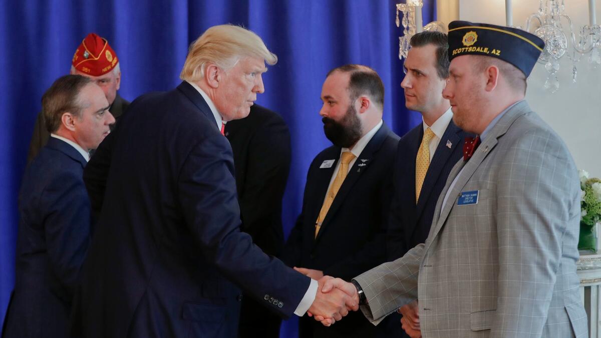 Veterans Affairs Secretary David Shulkin, left, and President Trump shake hands with military veterans after Trump signed the Veterans Affairs Choice and Quality Employment Act on Saturday in Bedminister, N.J.