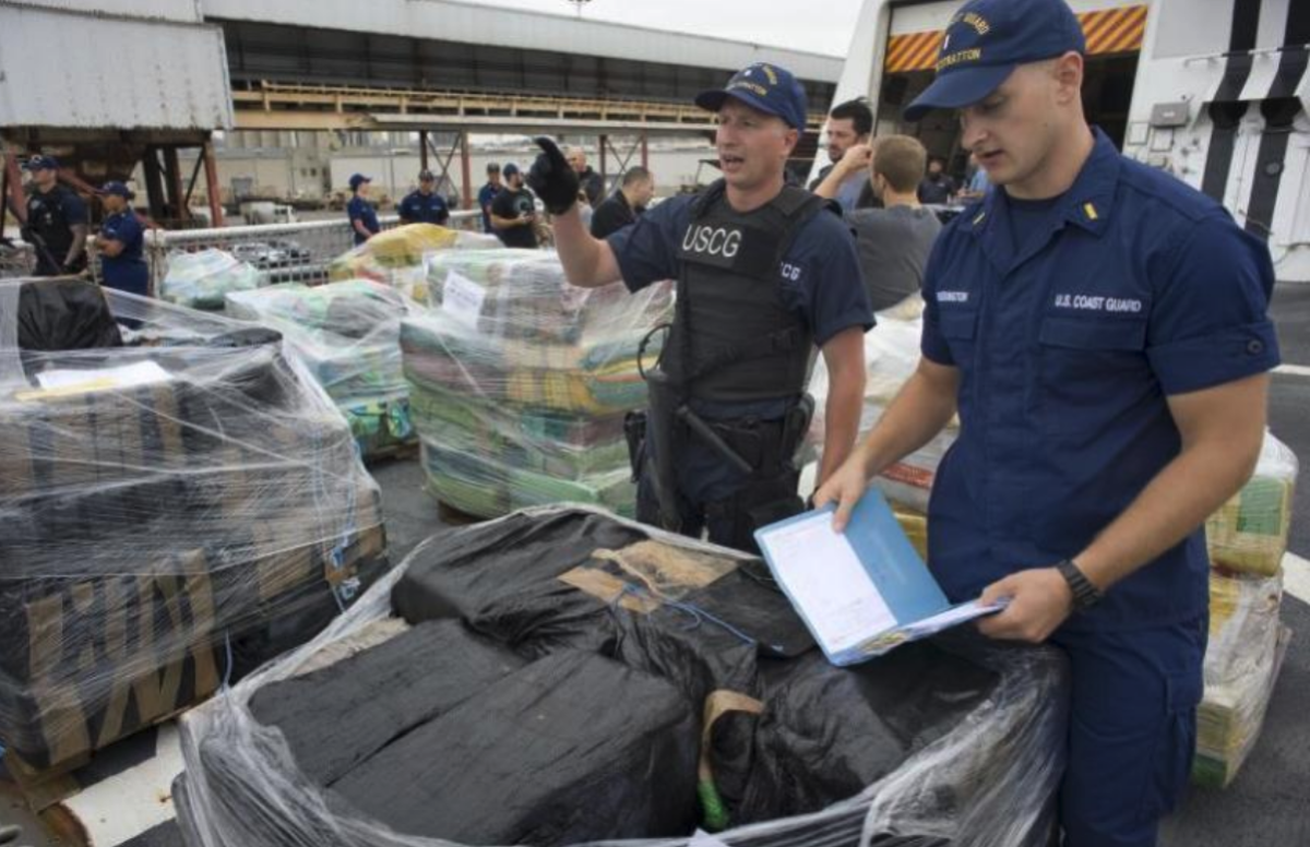 Dos agentes de la Guardia Costera revisan el registro de la cocaína incautada 