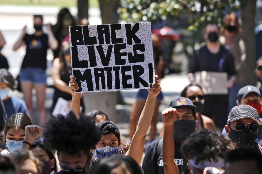 Jennffer Pizano, 28 of Anaheim, raises a Black Lives Matter sign during the Juneteenth Change Makers Vigil, sponsored by Black O.C., at Sasscer Park in Santa Ana on Friday, June 19, 2020. Dozens of attendees peacefully stood in the shaded area of the small park holding signs while speakers took turns at the podium. Organizer and executive director of Black O.C. Ferin Kidd said that they were out there "To show solidarity with one another. We understand that white supremacy is a big problem and a lot of us come from communities of color, we're people of color." One of the speakers, Dr. Karamo Chilombo of Los Angeles said that it was important to come out to events like this because "We are all one people, we all come from Africa, we are all one people, all one." Jennifer Pizano, 28 of Anaheim, added that "As a Latina, I want to show unity with everyone that's here for Black Lives because there needs to be justice. Something needs to change. We need to unite." Kidd added that "We have a lot of white allies out here who support our cause and we want and we want to come together as a community because you cannot spell community without unity."